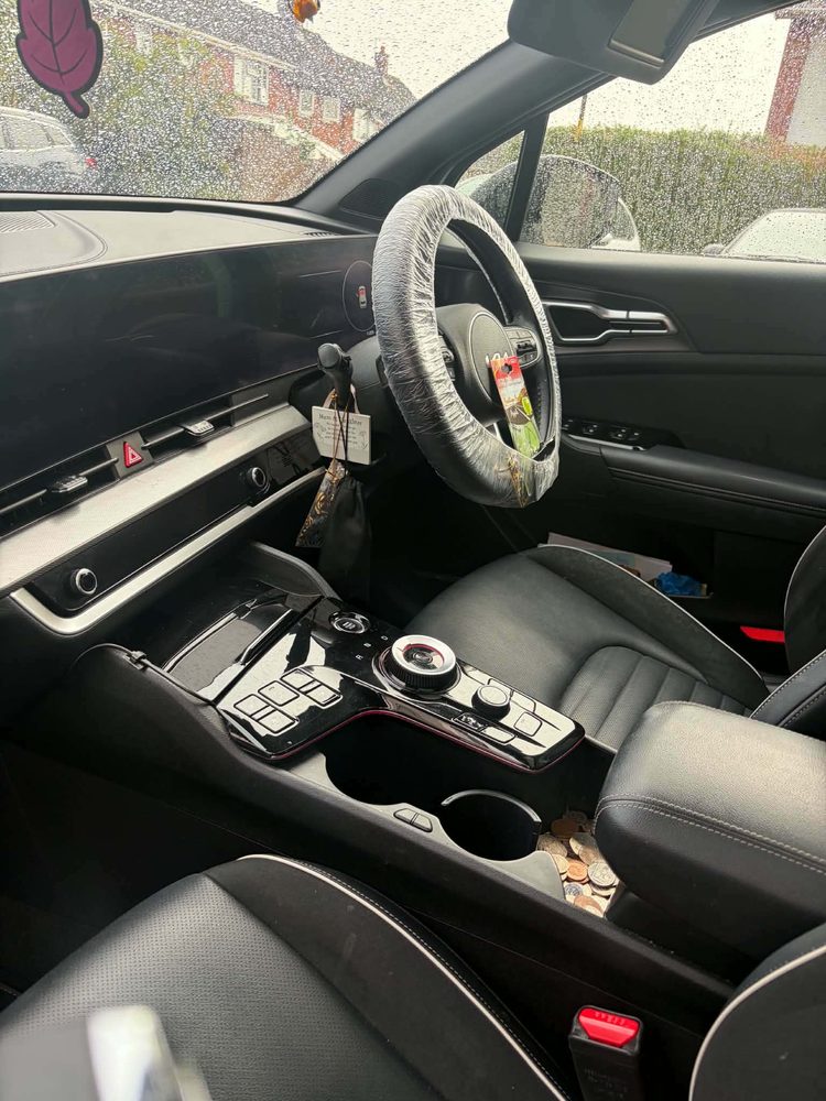The cleaned front cabin of a Kia Sportage with a protective cover fitted over the steering wheel