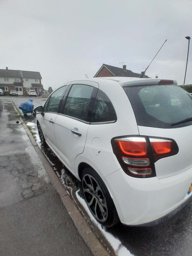 The rear of a white Citroen C3 cleaned at the roadside in Hereford